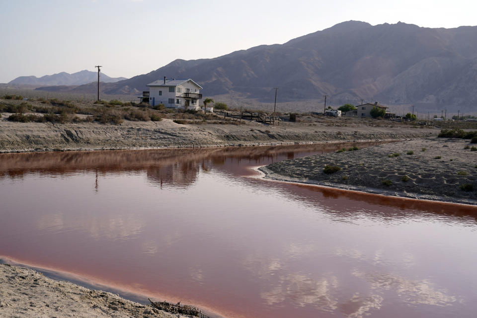 Clouds and nearby mountains are reflected in a polluted canal, once used as a boating dock, along the Salton Sea in Desert Shores, Calif., Wednesday, July 14, 2021. The Salton Sea, California&#39;s largest but rapidly shrinking lake, is at the forefront of efforts to make the U.S. a major global player in the production of lithium. (AP Photo/Marcio Jose Sanchez)